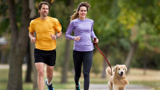 A couple is out for a run with their dog.